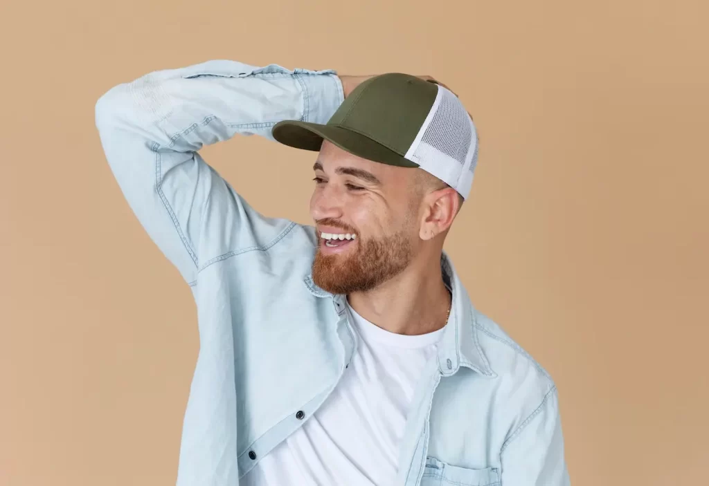 Homem usando um boné trucker. Um dos tipos de boné mais usados.