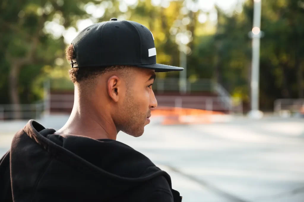 Homem utilizando um boné snapback, um dos tipos de chapéu masculino mais populares no mundo