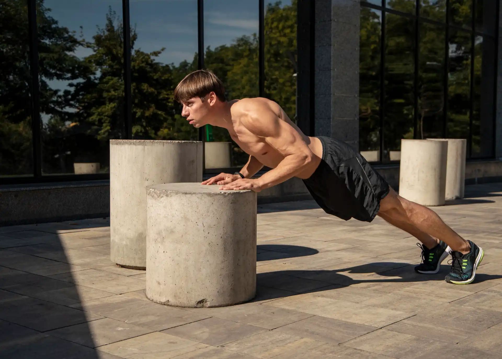 Homem fazendo uma flexão de braço inclinada. Esse é um movimento típico de um treino de peito em casa.