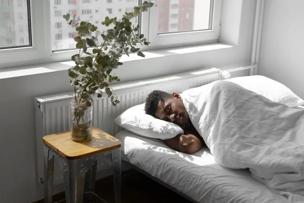 Homem dormindo em uma cama. Dormir bem é um dos pilares de um estilo de vida saudável.