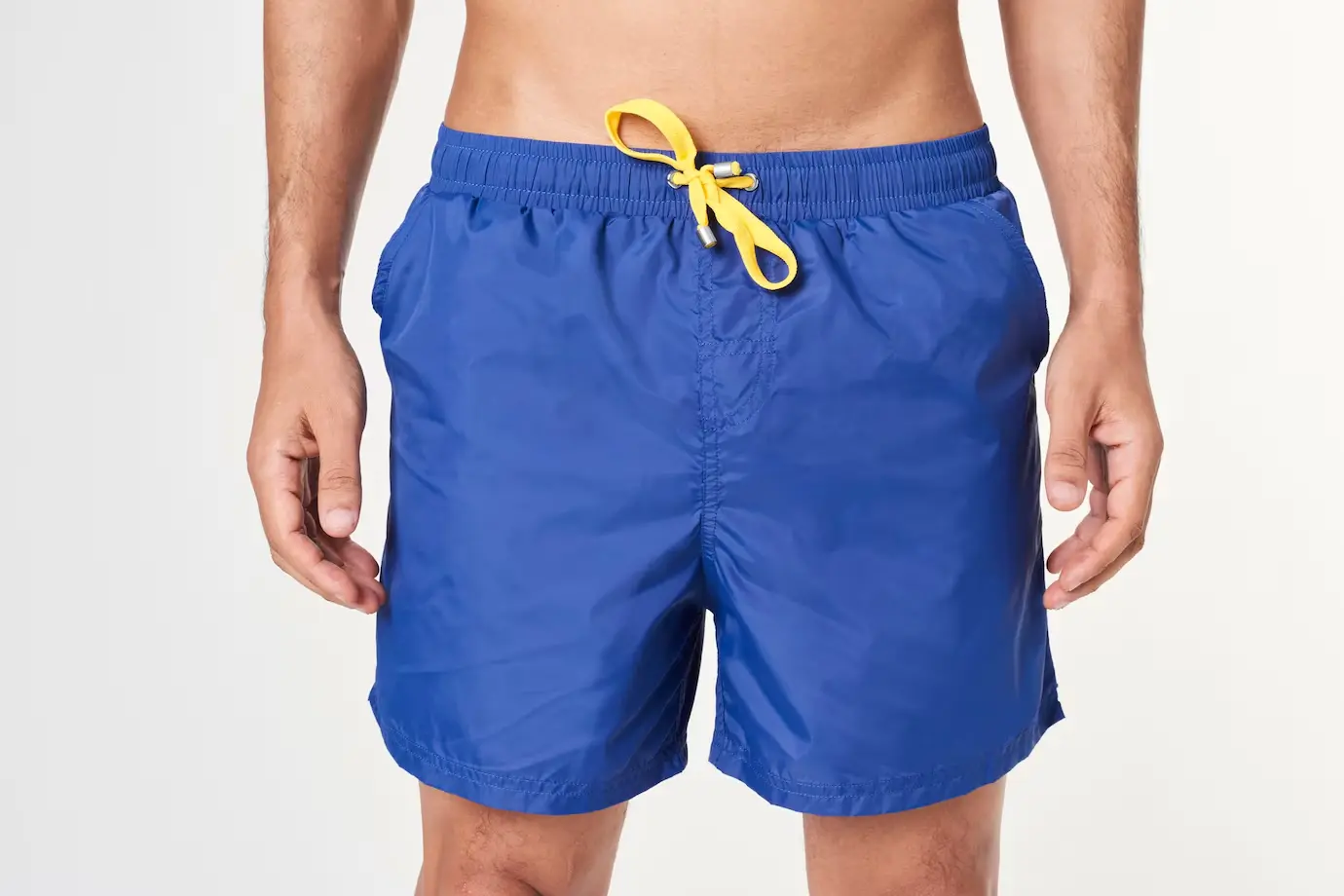 Short azul visto de perto. Essa é uma peça comum em um look masculino para praia.