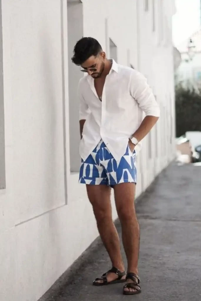 Homem usando um look masculino praia com bermuda, camisa e sandália.