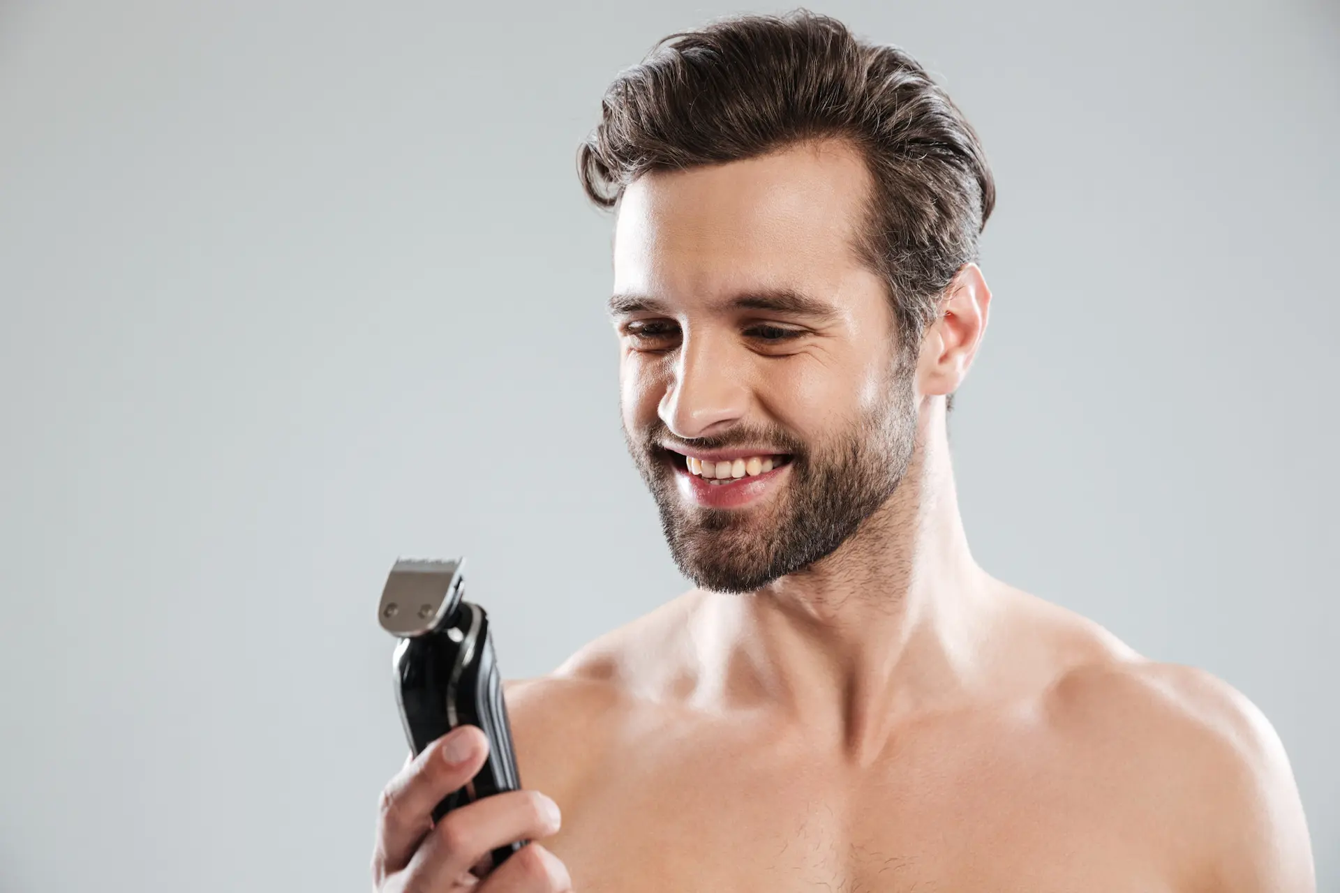 Homem segurando um aparador de barba.