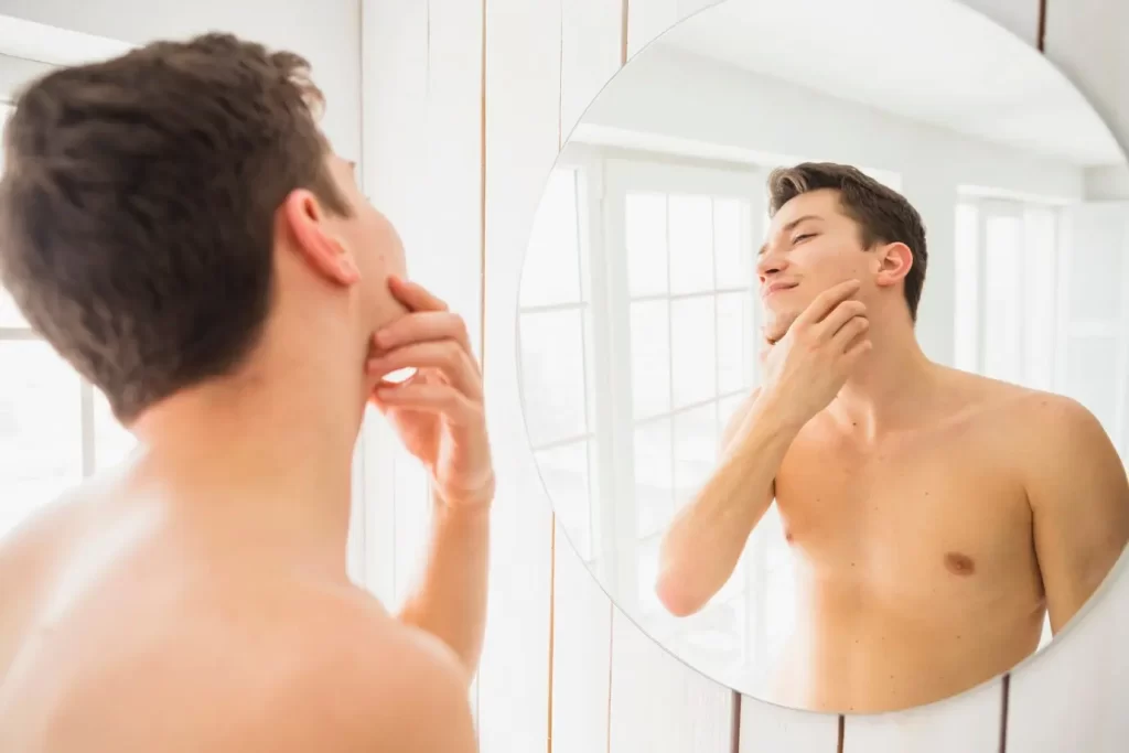 Homem se olhando no espelho após fazer a barba.