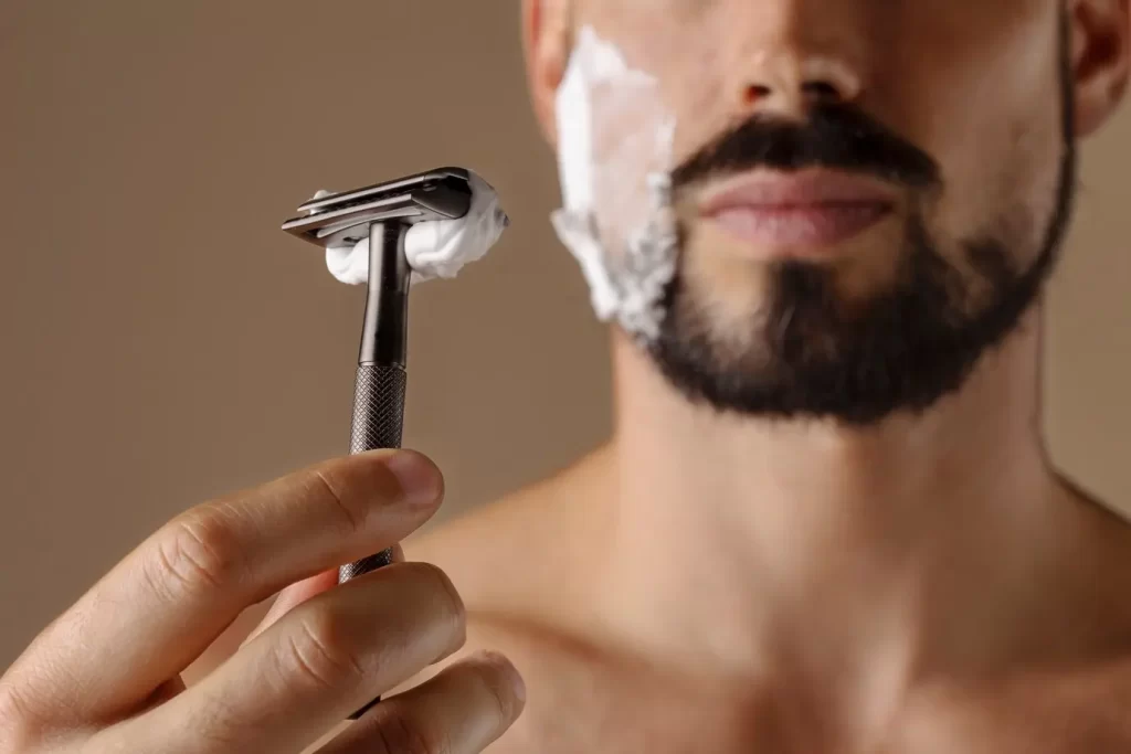 Homem fazendo a barba com uma lâmina