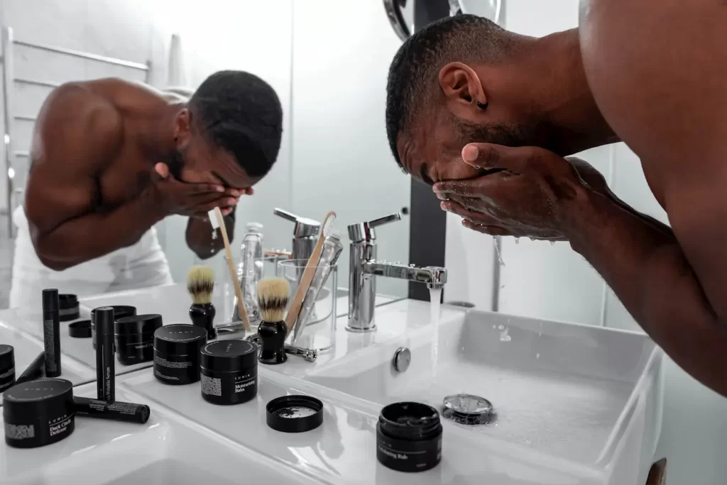 Homem lavando o rosto para iniciar sua rotina de skincare.