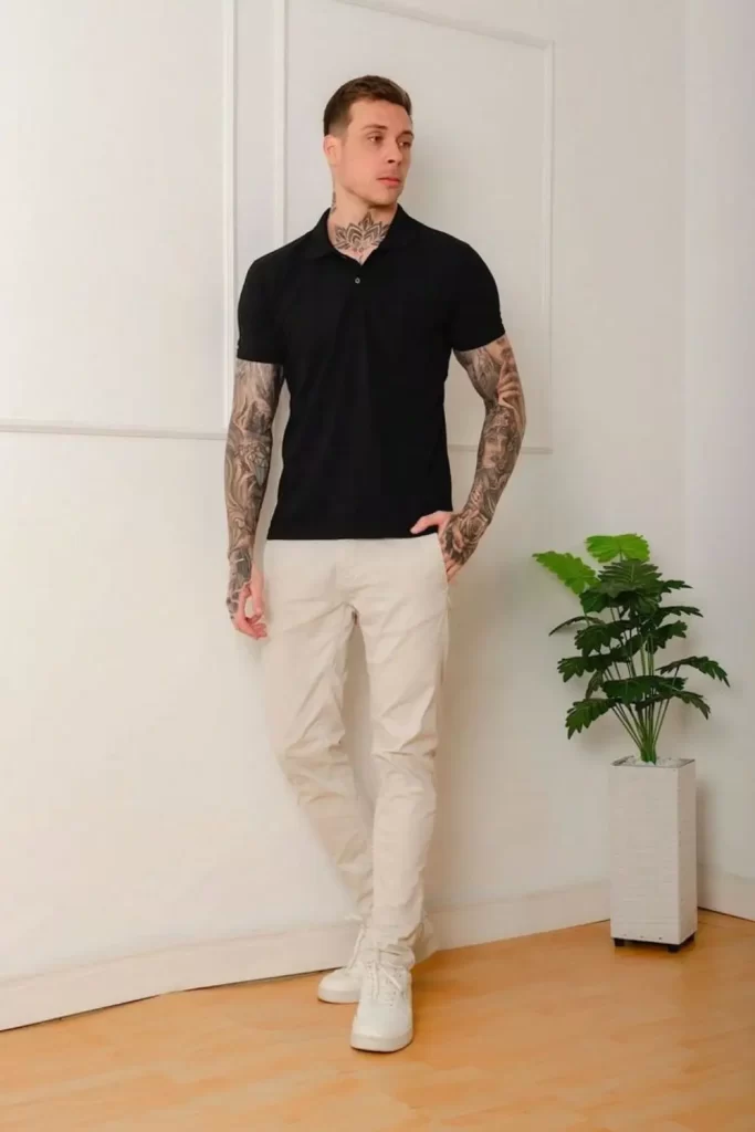 Homem usando camisa polo preta, calça chino bege clara e tênis branco.