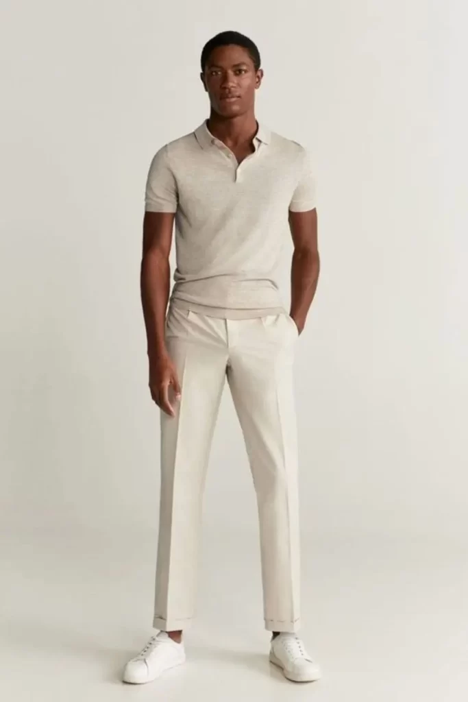 Homem vestido no estilo elegante. Ele usa camisa polo, calça chino e tênis.