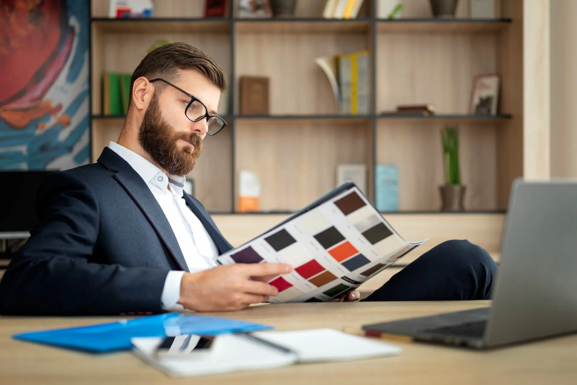 Homem vestido de forma elegante lendo uma revista.