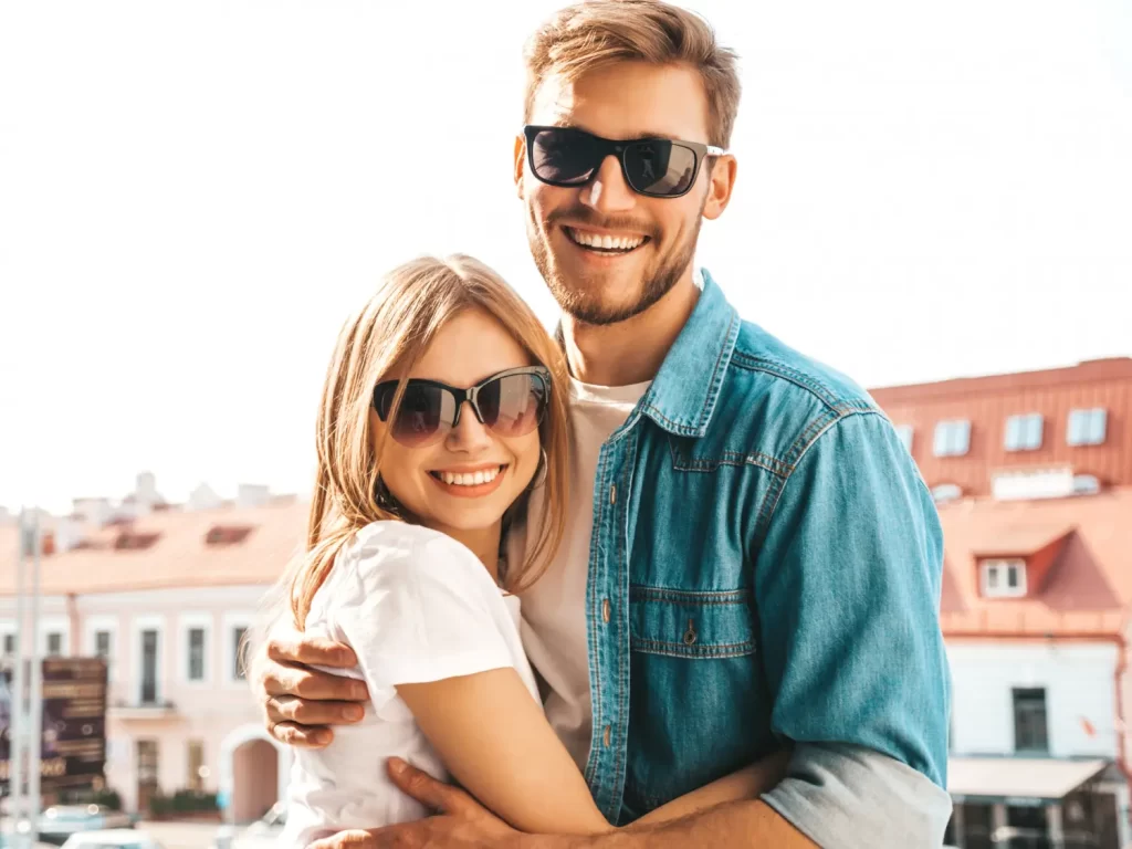 Casal de homem e mulher usando óculos de sol ao ar livre.