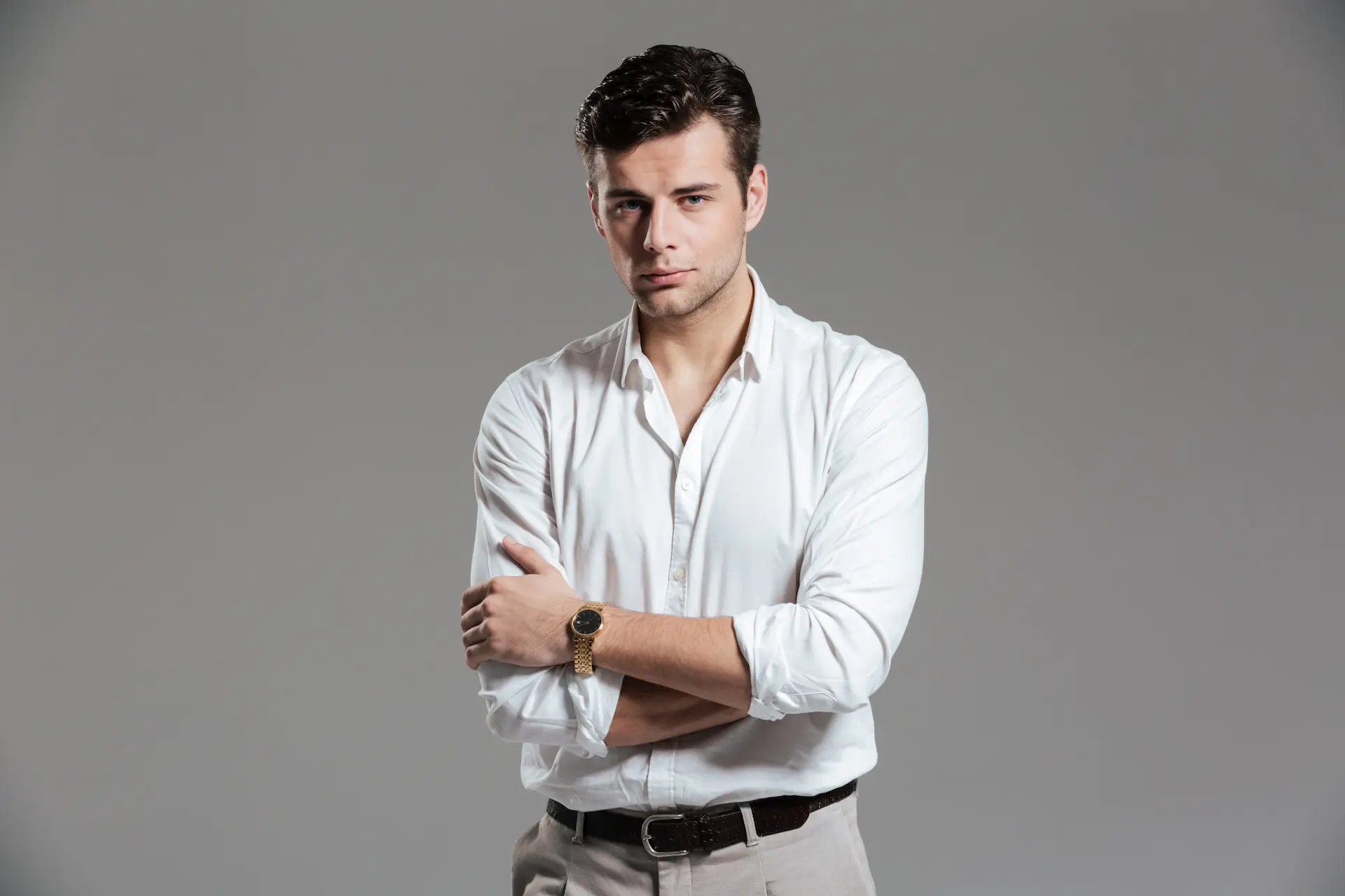 Homem vestido conforme o estilo clássico masculino, com camisa social e calça de alfaiataria.