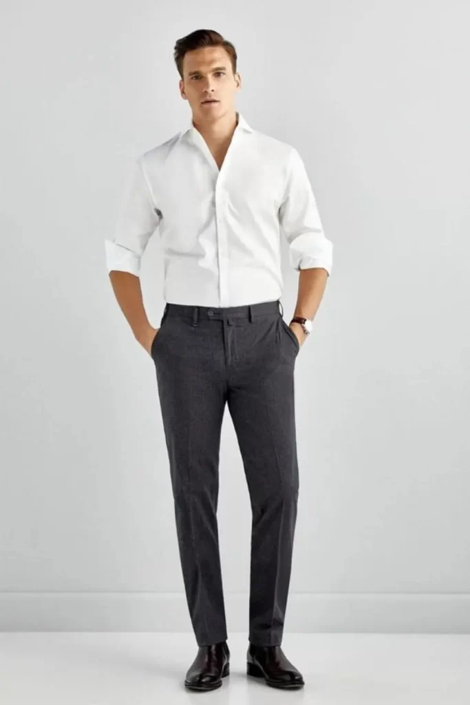Homem vestido no estilo elegante. Ele usa camisa social, calça de alfaiataria e sapato.