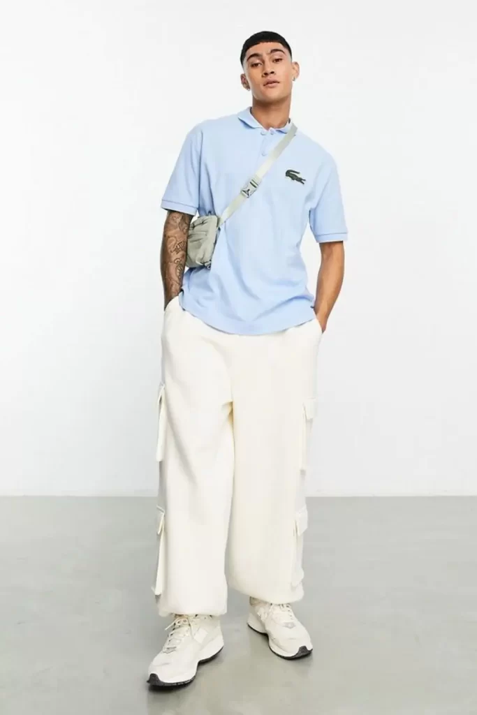 Homem usando camisa polo, calça larga e tênis.