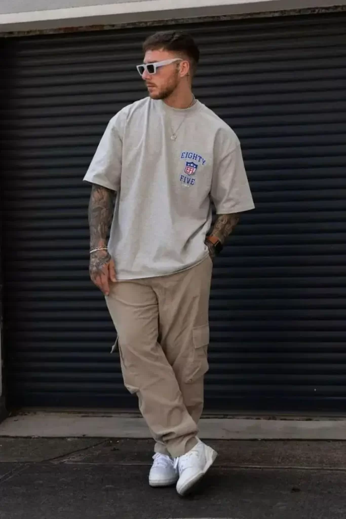 Homem usando camiseta oversized, calça cargo e tênis.
