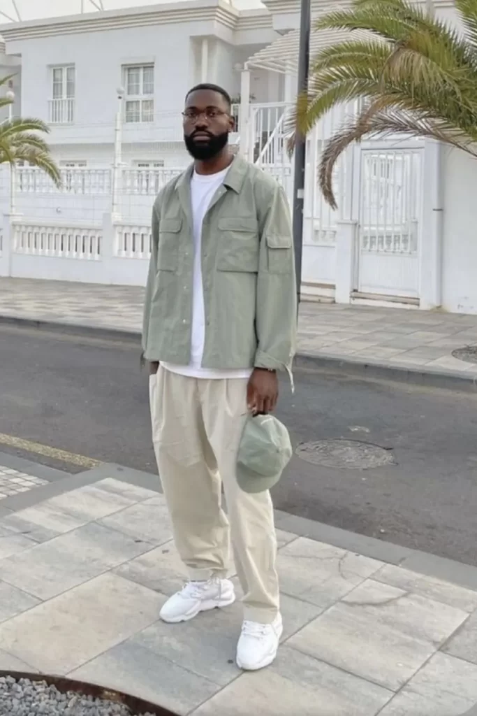 Homem usando camiseta básica, jaqueta, calça larga e tênis.
