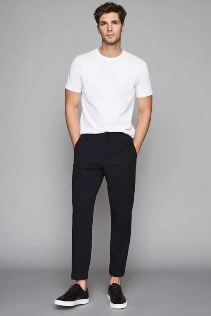 Homem usando camiseta básica, calça chino e tênis.