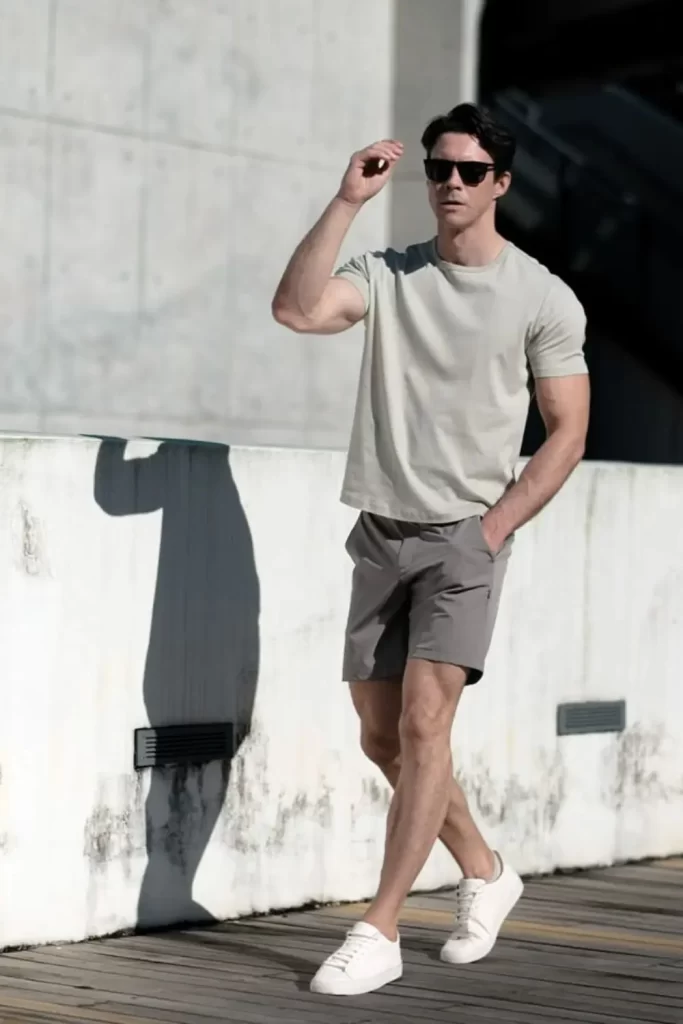 Homem usando camiseta básica, bermuda e tênis minimalista.