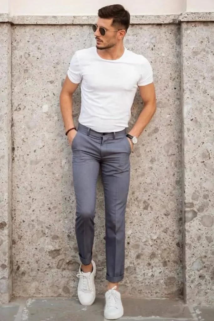 Homem usando calça de alfaiataria, camiseta básica, tênis e óculos de sol.