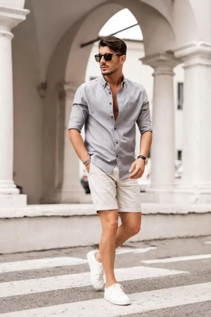 Homem usando camisa social, bermuda e tênis casual.