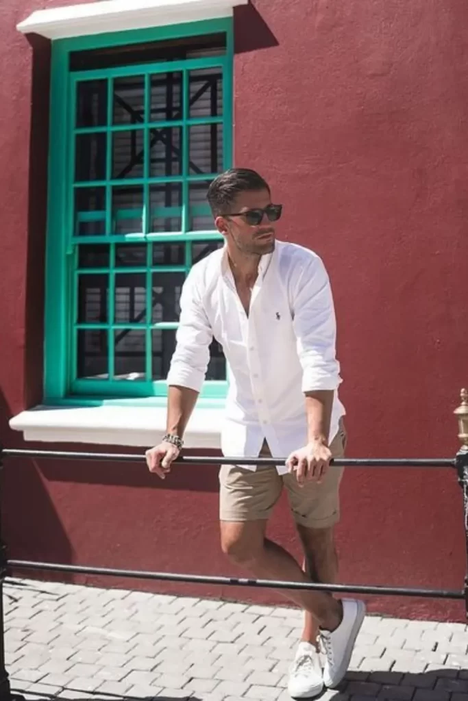 Homem usando camisa social, bermuda e tênis casual.