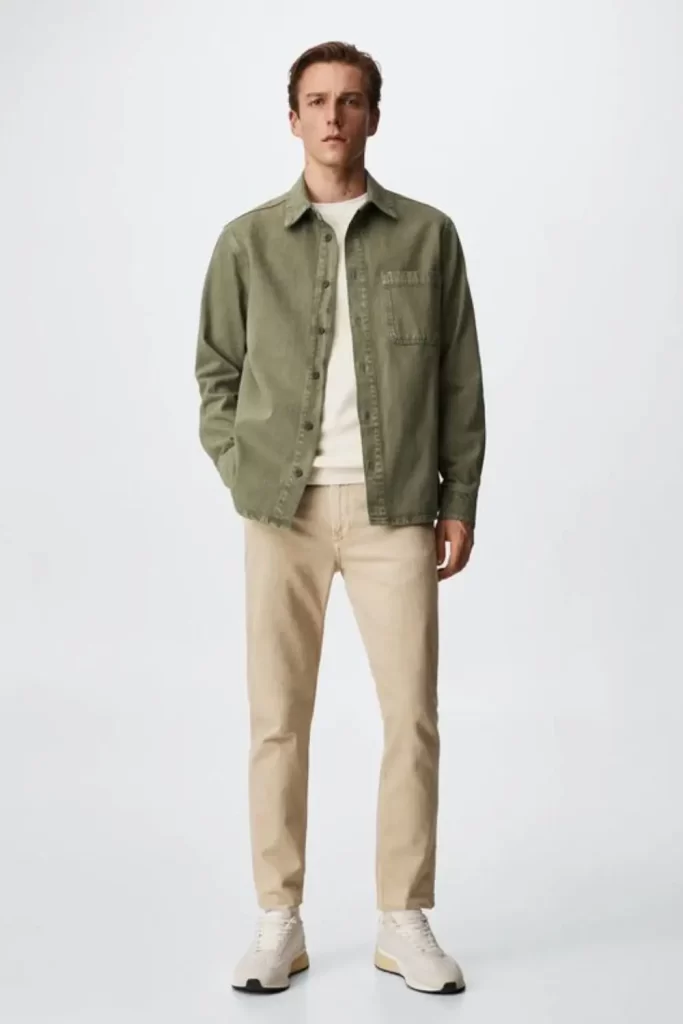 Homem usando calça chino, camiseta básica, jaqueta e tênis casual.